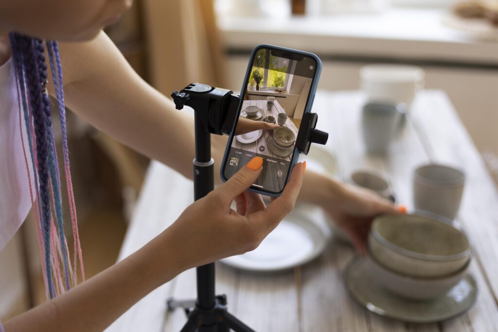 photo woman's smart phone for video content for her business with ceramic kitchenware